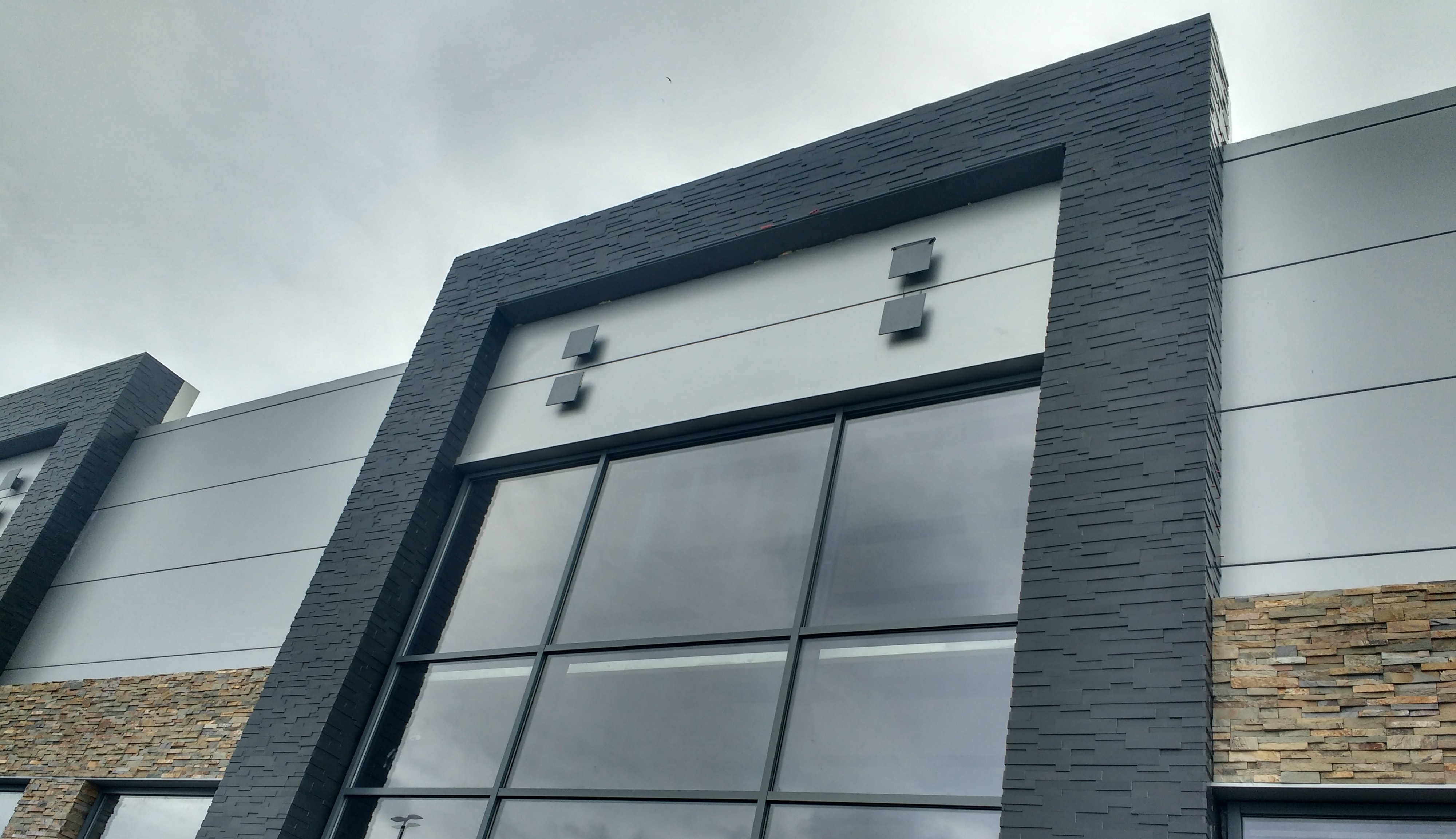 Smooth stone veneer used on commercial entryway feature with prominent outside corners